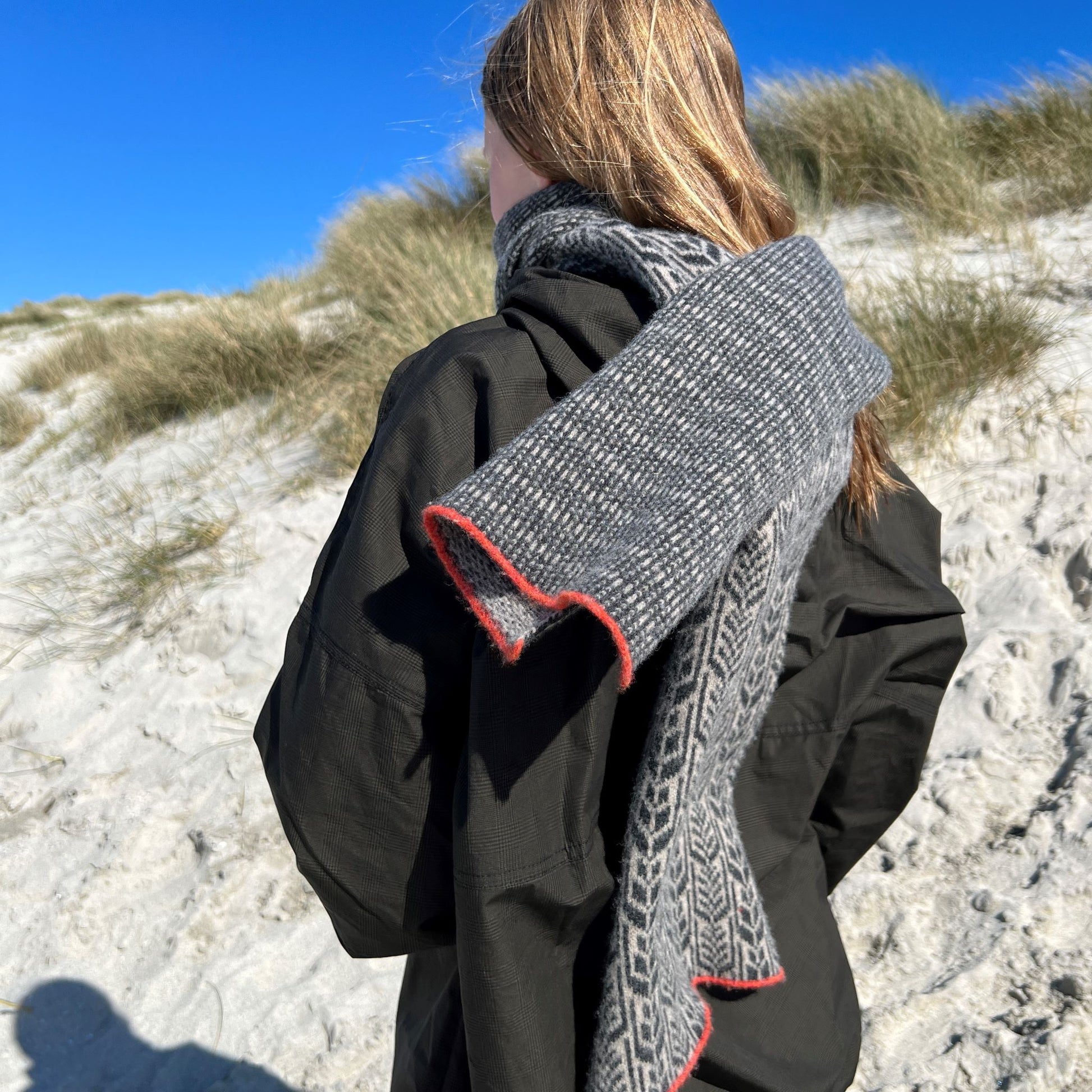 All our scarves are knitted using a punch-card system on a manual vintage knitting machine and are 100% Merino lamb's wool.  Dry clean or wash by hand. Seen here in Pebble.